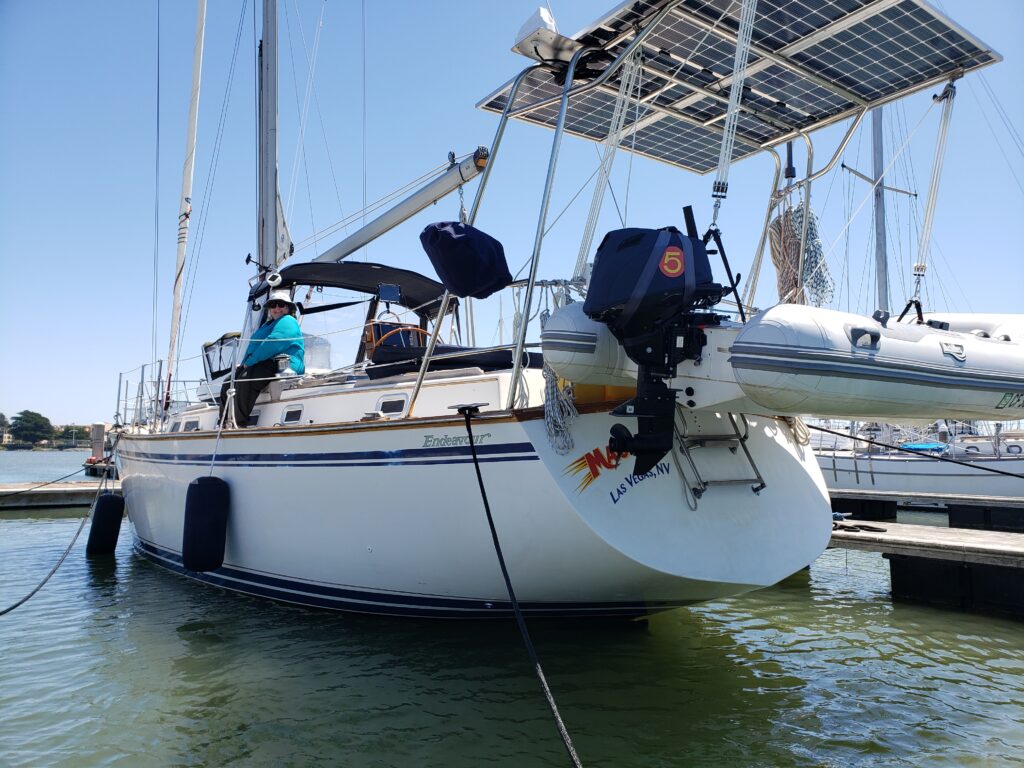 stern view of a sailboat with dinghy and solar panels